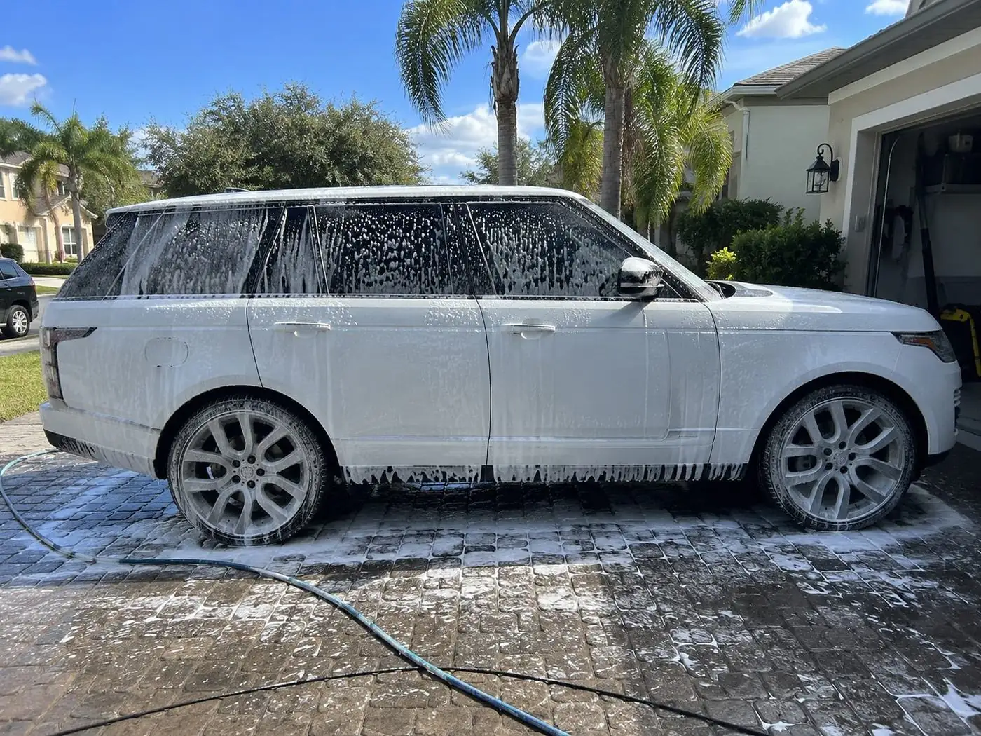 White SUV covered in foam during a hand wash